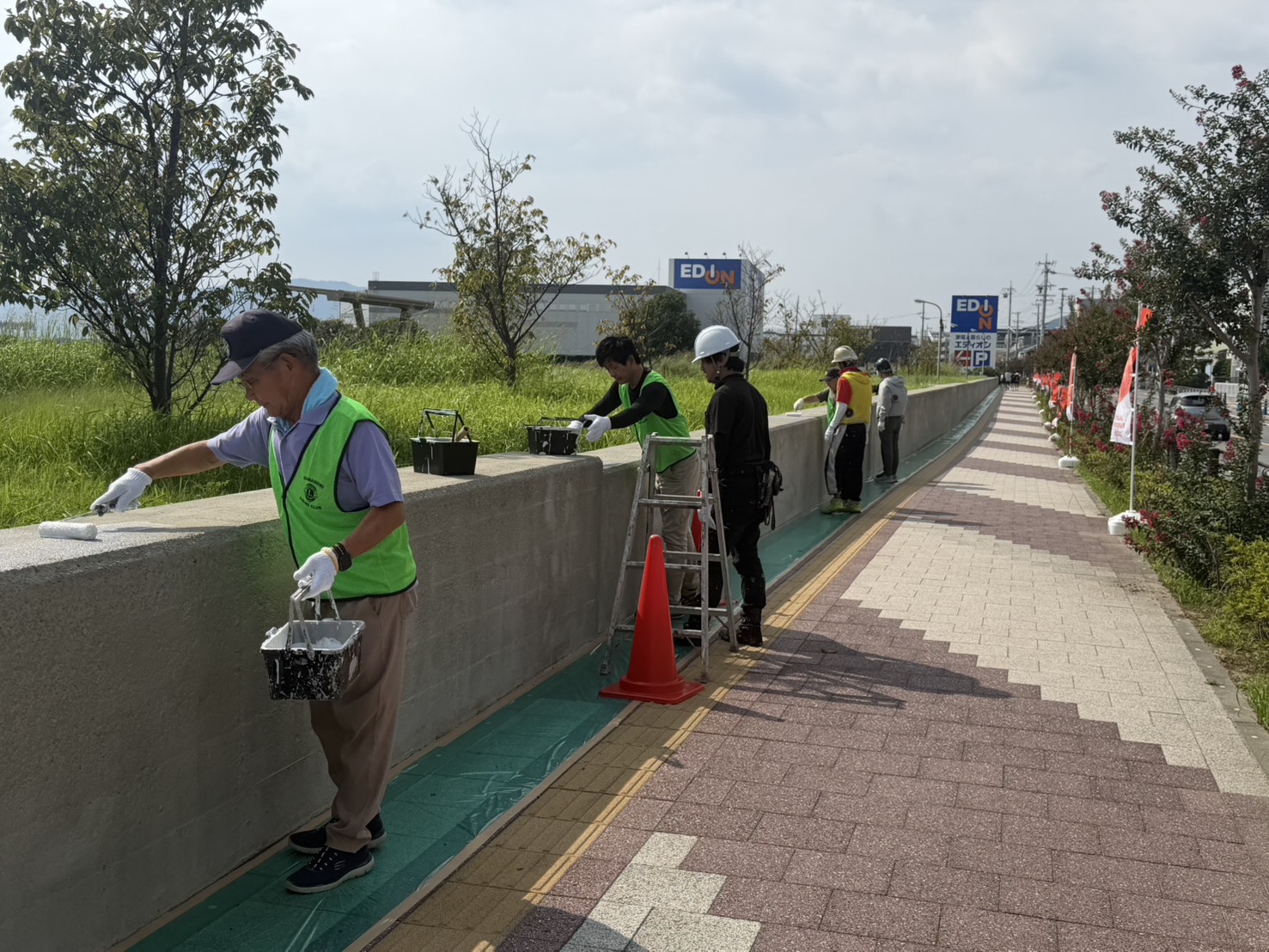 堤防アートの下塗りを行う